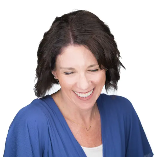 A laughing woman in a blue top with dark shoulder-length hair.